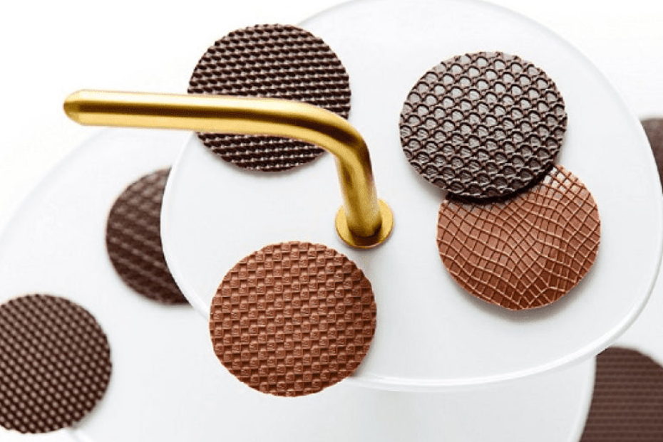 Chocolate wafer cookies with a gold handle on a white plate